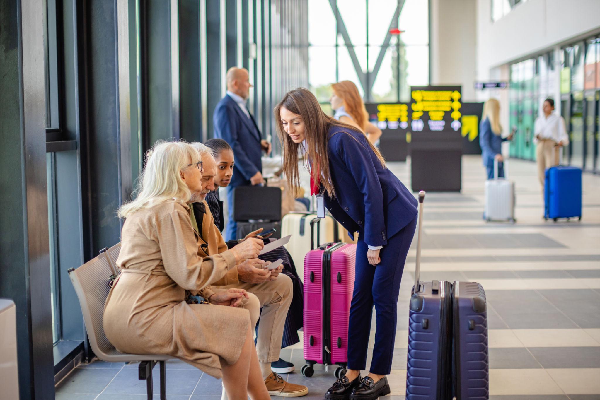 Airport ground staff handling customers and assisting passengers at the airport check-in counter.